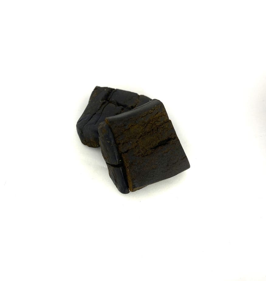 Close-up of Buddha Hash a dark brown compressed cannabis concentrate block with rich earthy texture