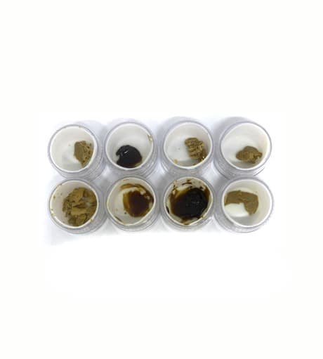 Golden amber live rosin concentrate in a small glass jar, a high-potency cannabis extract with 186mg THC