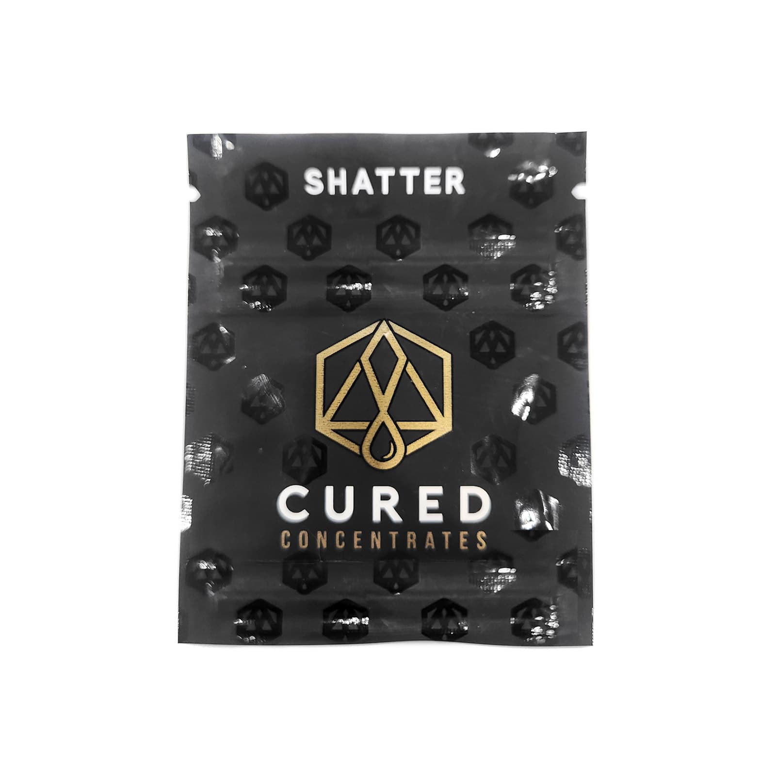 Golden amber indica shatter concentrate with a glassy translucent appearance, broken into thin brittle fragments
