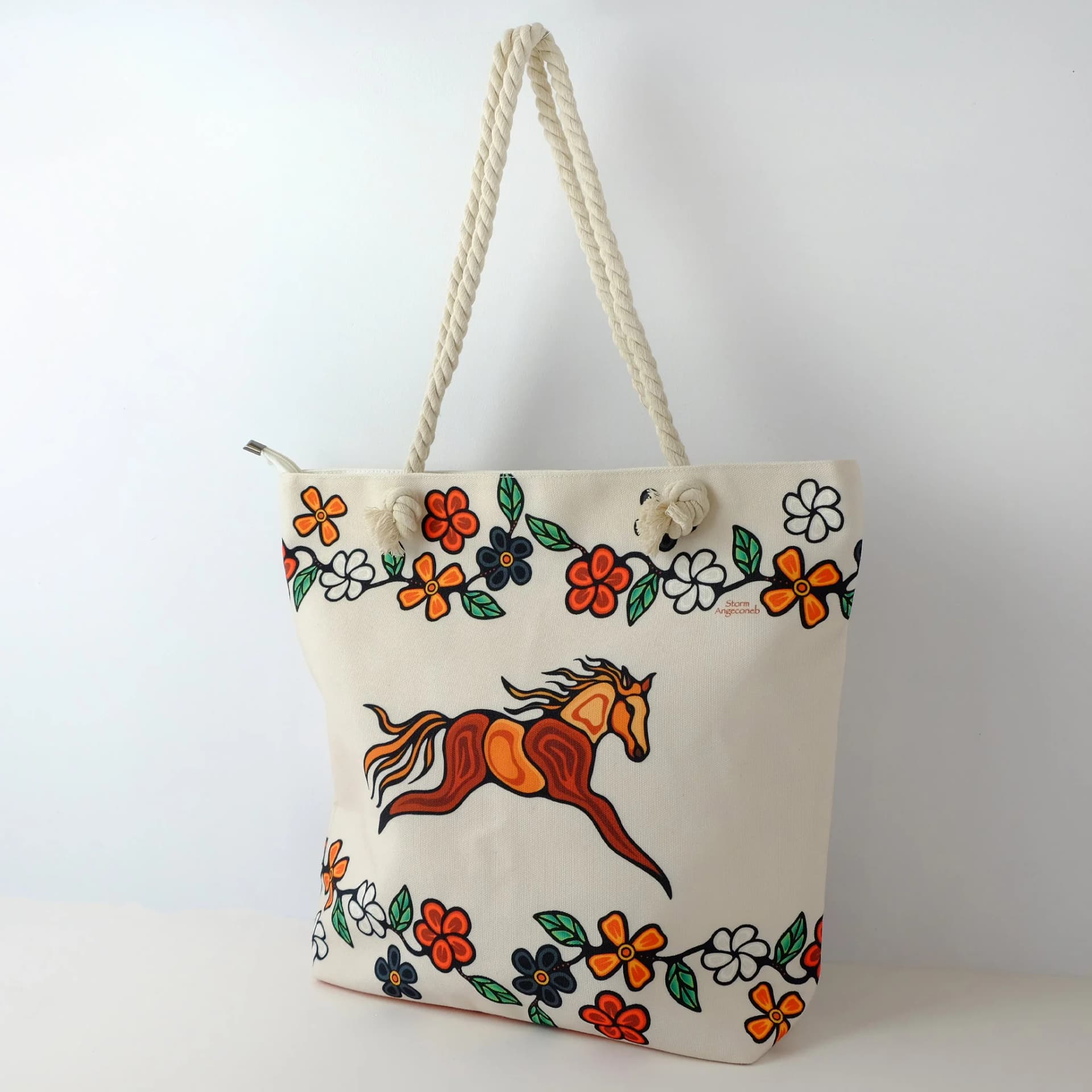 Tote bag featuring indigenous art design with horses by Storm Angeconeb in earthy tones