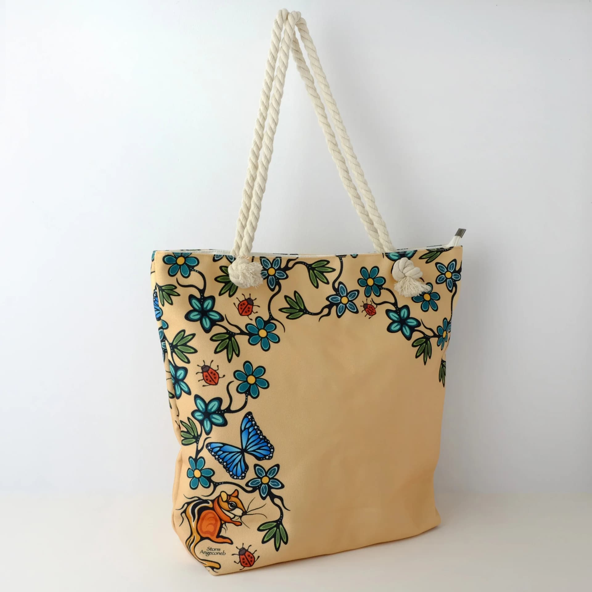 Tote bag featuring Indigenous art with little critters design by Storm Angeconeb in earthy tones