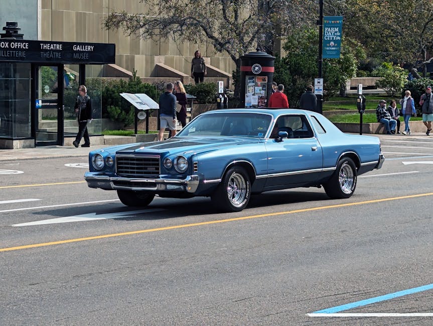 Classic car driving on a sunny day in Charlottetown, capturing urban life and vintage aesthetics.