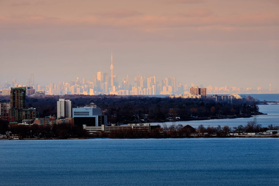 Scenic view of Toronto skyline from Hamilton, Ontario, with Lake Ontario in the foreground.
