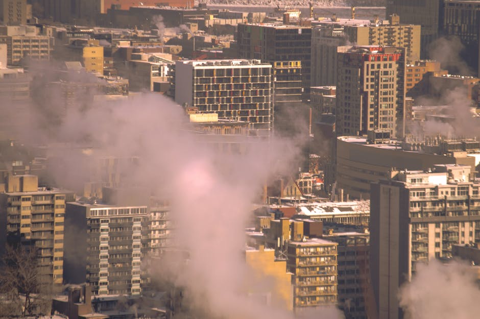 City skyline with smoke rising from buildings, showcasing urban winter scene in Montreal.