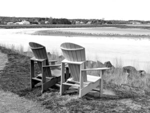 Peaceful riverfront scene with wooden chairs overlooking water in Truro, Nova Scotia.