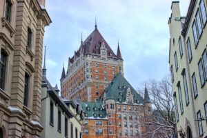 View of Château Frontenac surrounded by historic buildings in snowy Québec City, Canada.