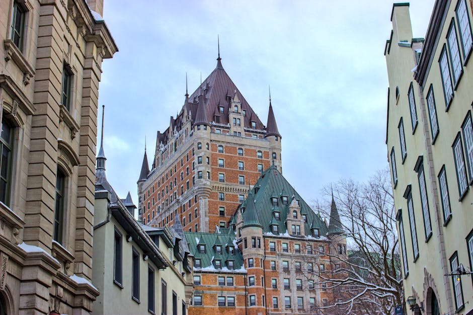 View of Château Frontenac surrounded by historic buildings in snowy Québec City, Canada.
