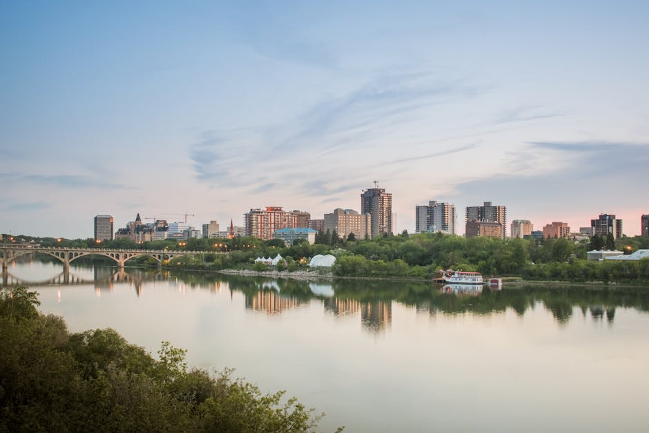 Stunning view of Saskatoon skyline reflecting on the South Saskatchewan River at dusk.