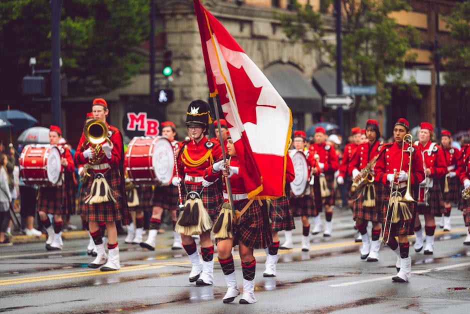 Festive marching band in Victoria, BC, celebrating with Canadian flags and colorful costumes.